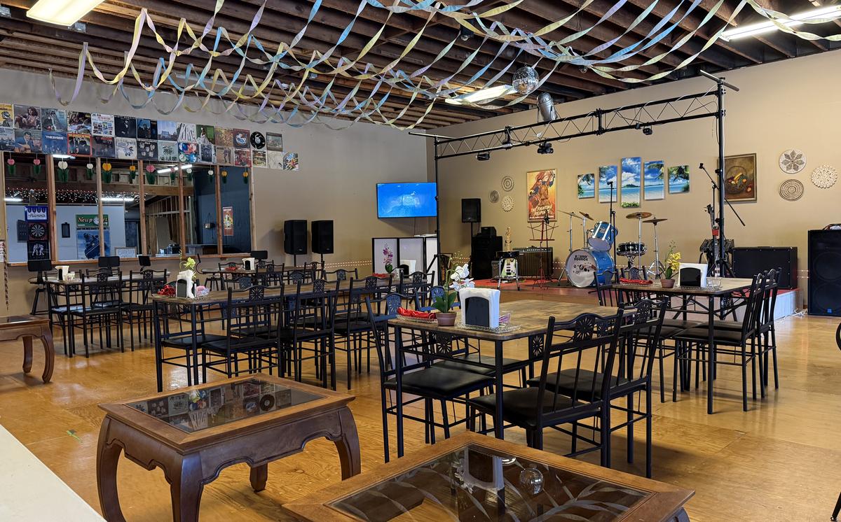Wide view of the dining hall with record covers on the wall and the stage in back