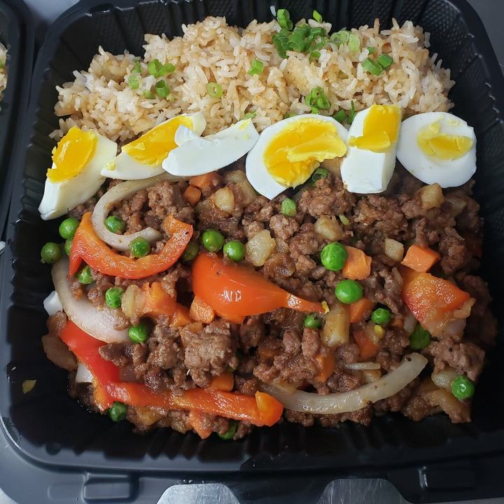 Giniling with ground beef, peas, carrots and peppers beside seasoned rice and boiled egg slices