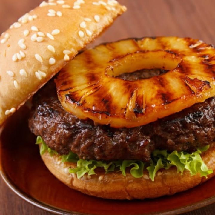 Hawaiian burger with a char grilled beef patty, a ring of grilled pineapple and green leaf lettuce on a toasted sesame seed bun