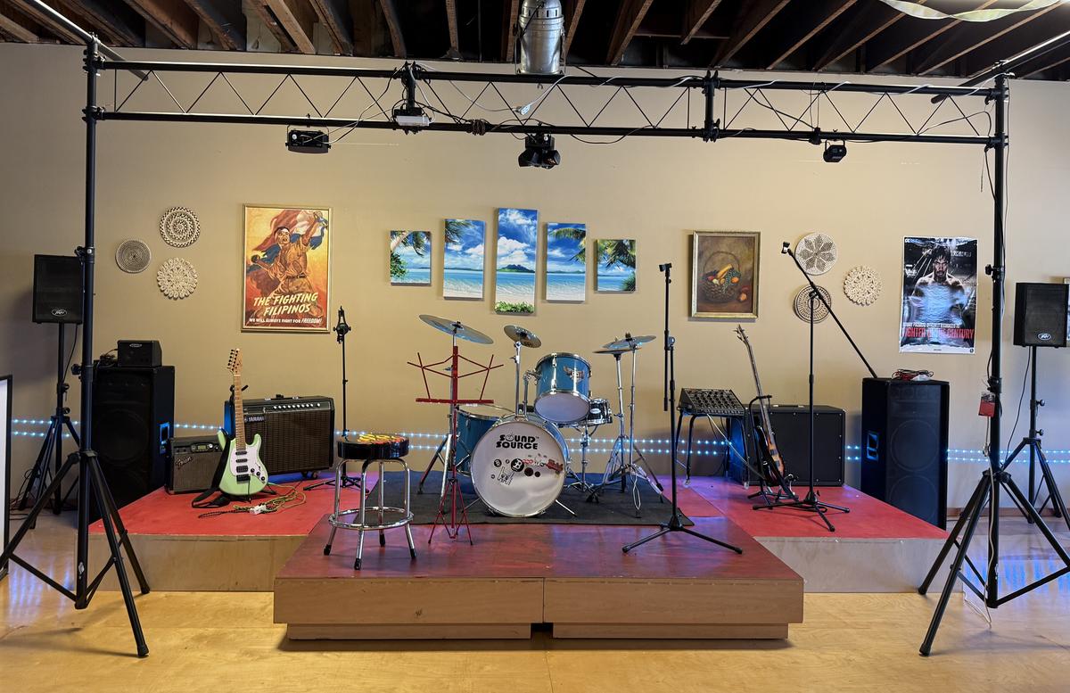 The live music stage with a drum kit, guitars, amps and stage lighting
