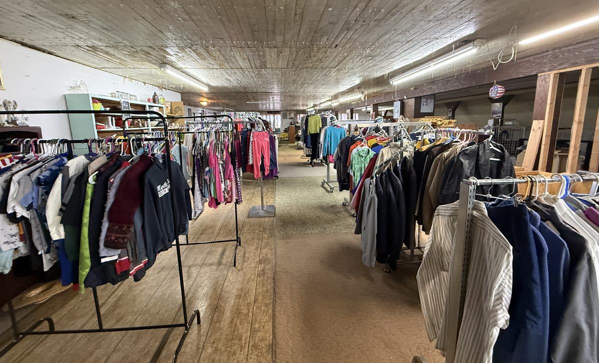 A long hall of clothing racks in the upstairs thrift section