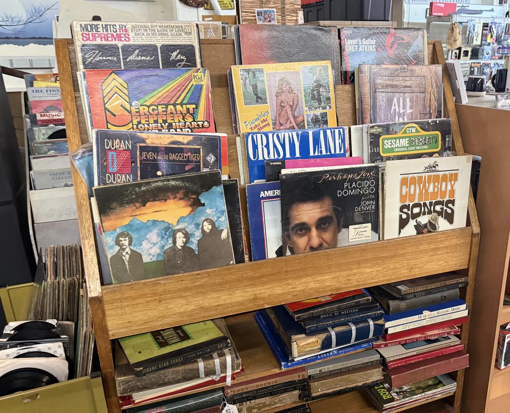 Wooden rack of vintage vinyl records including classic rock and country albums